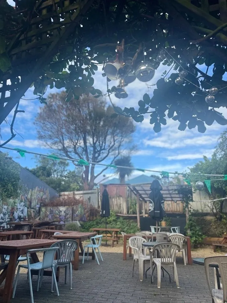 Baobab's sunny courtyard garden with tables under leafy trees