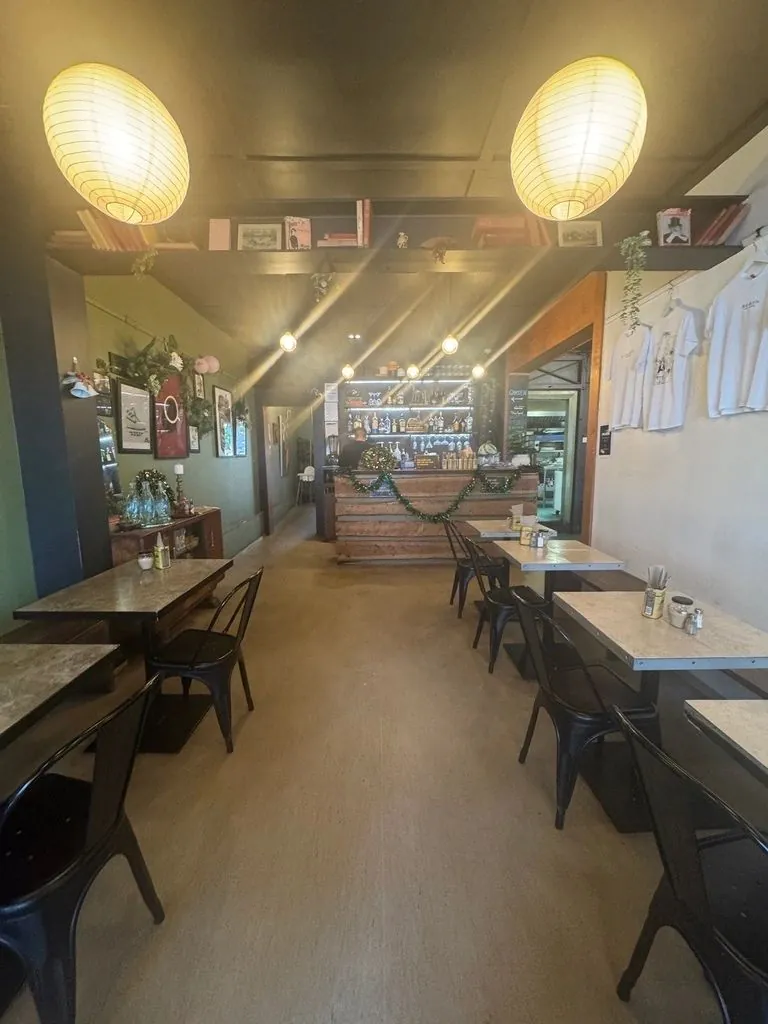 Long café interior with lanterns and wooden tables